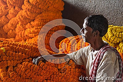 Indian seller with flower garland on Flower market at Mallick Ghat in Kolkata. India Editorial Stock Photo