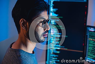 Indian software development working on coding computer screen and flowchart at night in modern office Stock Photo