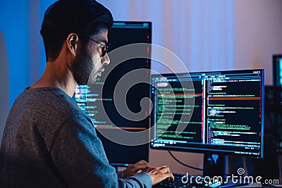 Indian software development working on coding computer screen and flowchart at night in modern office Stock Photo