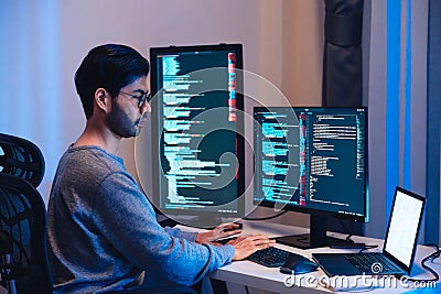 Indian software development working on coding computer screen and flowchart at night in modern office Stock Photo