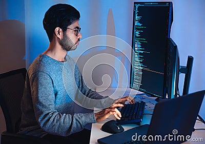 Indian software development working on coding computer screen and flowchart at night in modern office Stock Photo