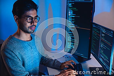 Indian software development working on coding computer screen and flowchart at night in modern office Stock Photo