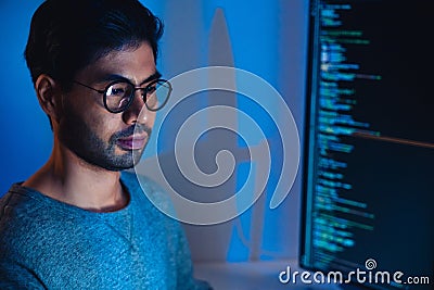 Indian software development working on coding computer screen and flowchart at night in modern office Stock Photo