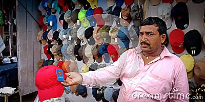 an indian street shopkeeper selling caps on road Editorial Stock Photo