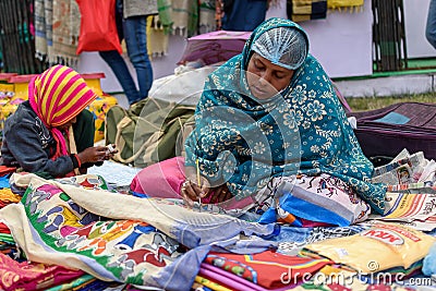 An Indian Unidentified middle-aged woman paints on colourful handicraft items for sale in Kolkata in handicrafts trade fair. It is Editorial Stock Photo