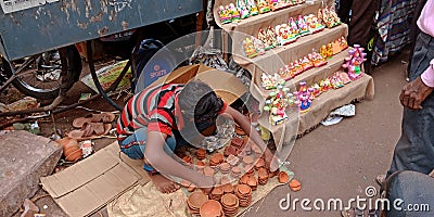 an indian village boy selling soil made lamp on street during diwali festival Editorial Stock Photo