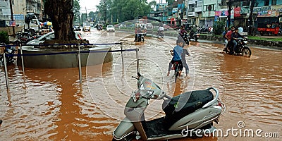 indian village kids riding cycle during flood on road in India aug 2019 Editorial Stock Photo