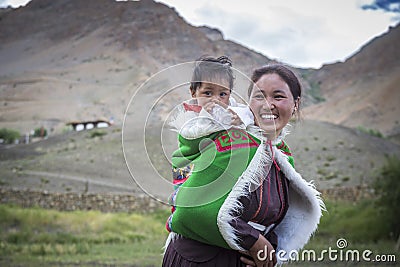 Indian woman carrying baby on her back in spiti valley Stock Photo