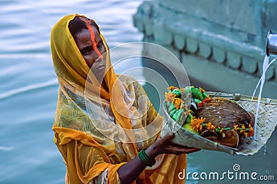 Indian Hindu woman devotee offering prayers to the Sun God during Chhath Puja in Varanasi Editorial Stock Photo