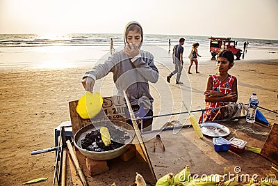 Indian woman preparing roasted sweet yellow corn at the beach Editorial Stock Photo