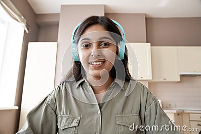 Indian woman student teacher wearing headphones looking at web cam. Stock Photo