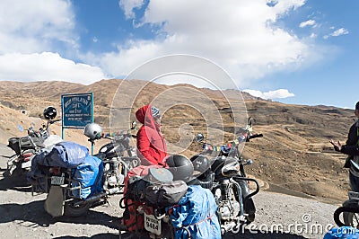 Indian woman traveler trekker and Biker standing beside her motorcycle, hiking high Himalayan Mountain region outing and exploring Editorial Stock Photo