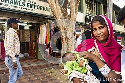 Indian women beggar or untouchables caste hold baby and begging money from travelers people in New Delhi, India Editorial Stock Photo