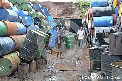 Indian workers cleaning oil barrels Editorial Stock Photo