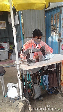 An Indian young man using sewing machine Editorial Stock Photo