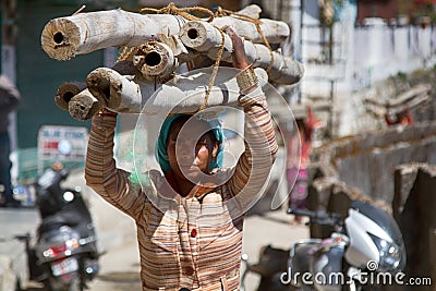 Indian young woman on the head of thick bamboo stalks Editorial Stock Photo