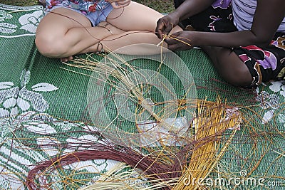 Indigenous Australians aboriginal woman teaching a tourist Aboriginal basket weaving Stock Photo