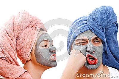 An indignant girl beats a guy in the face , mask for skin man and woman, guy with a girl make a mask for the skin together, funny Stock Photo