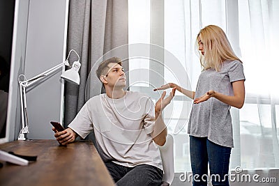 Indignant woman expresses dissatisfaction with lazy husband Stock Photo