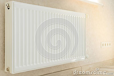 Individual heating radiator on a wall at an apartment. Stock Photo