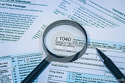 1040 Individual Income Tax Return Form with pen and magnifying glass up detailed close up Concept for personal individual finance Editorial Stock Photo