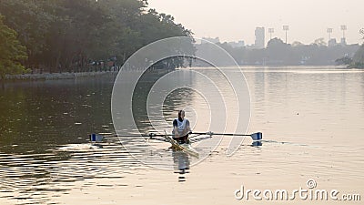 Individual Sports Speed Rower in Single scull crew rowing boat sliding racing shell on lake water oars in motion sitting sliding Editorial Stock Photo