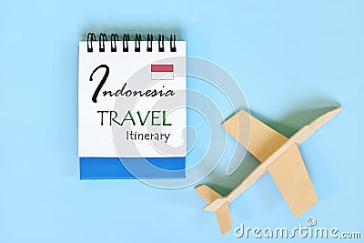 Indonesia travel plan or itinerary written on blue notepad with flag and wooden airplane. Tour guide and outline. Stock Photo
