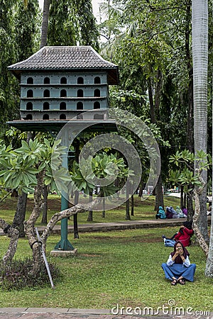 Indonesian people enjoy a day off at Medan Merdeka next to a bird house in Jakarta, Indonesia Editorial Stock Photo