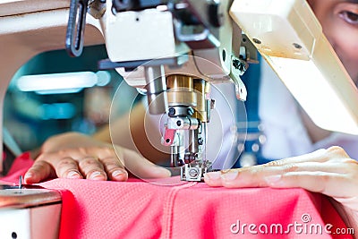 Indonesian Seamstress in Asian textile factory Stock Photo