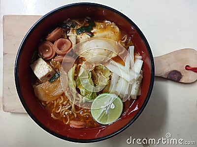 Indonesian spicy hot food called seblak is made from noodles, crackers, meat, and various kinds of toppings. Stock Photo