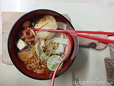 Indonesian spicy hot food called seblak is made from noodles, crackers, meat, and various kinds of toppings. Stock Photo