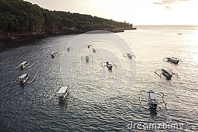 Indonesian traditional boats with outriggers Bangka at harbor in sunset. Stock Photo