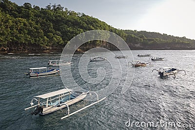 Indonesian traditional boats with outriggers Bangka at harbor in sunset. Stock Photo