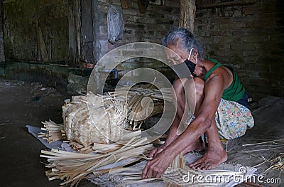Indonesian woman making traditional bamboo cantainer Editorial Stock Photo