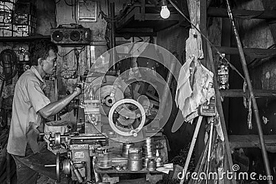 Indonesian worker operates his machine in an old worshop in Jakarta, Indonesia Editorial Stock Photo