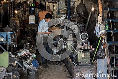 Indonesian worker operates his machine in an old worshop in Jakarta, Indonesia Editorial Stock Photo