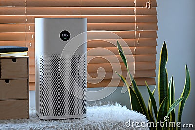 Air purifier in living room for filter and cleaning removing dust PM2.5 and virus in home. Stock Photo