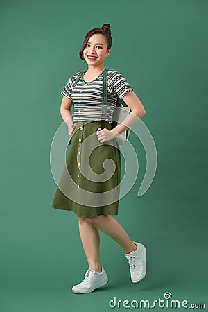Indoor picture of young good-looking teenage girl isolated on green background Stock Photo