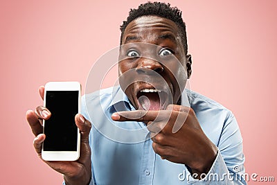 Indoor portrait of attractive young black man holding blank smartphone Stock Photo