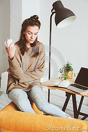 Indoor portrait of beautiful feminine thoughtful young women alone in the room with cup of tea or coffee Stock Photo