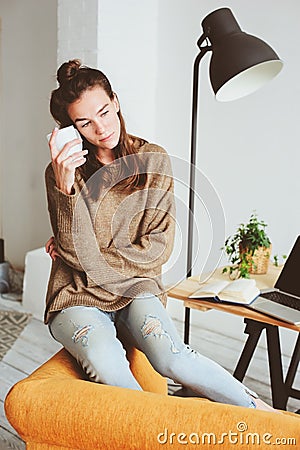 Indoor portrait of beautiful feminine thoughtful young women alone in the room with cup of tea or coffee Stock Photo