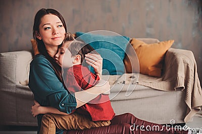 indoor portrait of happy loving mother comforting toddler son at home. Stock Photo