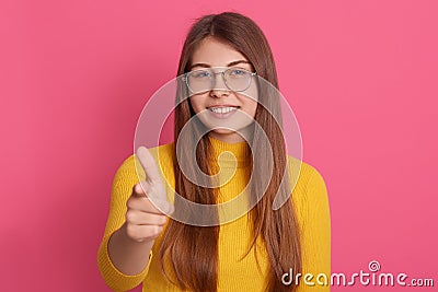 Indoor portrait of pleasant cheerful young lady posing isolated over pink background in studio, smiling sincerely, making gesture Stock Photo