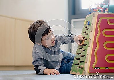 Indoor Portrait preschool boy playing in kid club, Child having fun playing colorful toys in kid playroom. Kid boy playing with Stock Photo