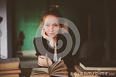 Indoor portrait of redhead happy student woman learning or reading books Stock Photo