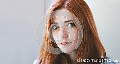 Indoor portrait of young woman with red hair and freckles Stock Photo