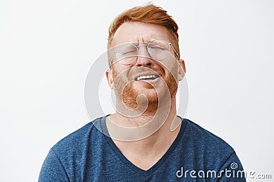 Indoor shot of gloomy and upset redhead mature man with beard, tilting head behind, frowning and grimacing, complaining Stock Photo