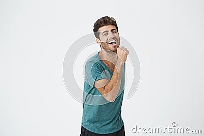 Indoor shot of handsome excited lucky young hipster in excitement, cheering, because of passing all exams at college Stock Photo