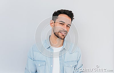 Indoor shot of handsome young male model with positive expression, blinks eye and smiles happily. People, lifestyle, facial Stock Photo