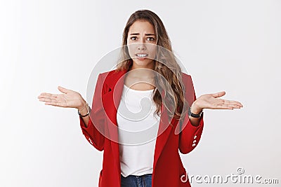 Indoor shot of perplexed worried confused good-looking young modern female wearing red jacket shrugging bothered hands Stock Photo